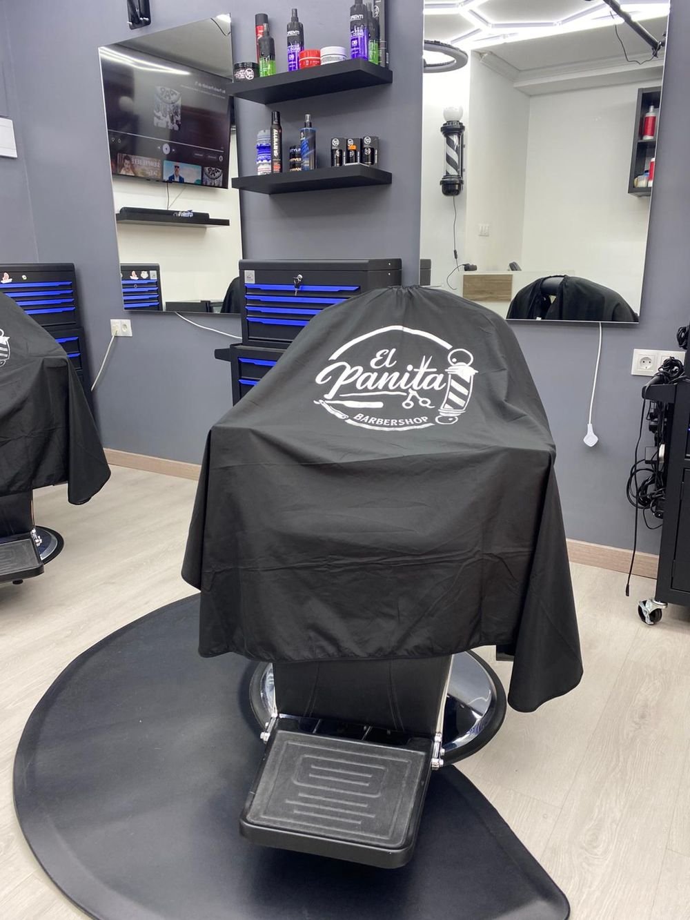 Sillon de barbero con la capa bordada con el logo de El Panita Barbershop