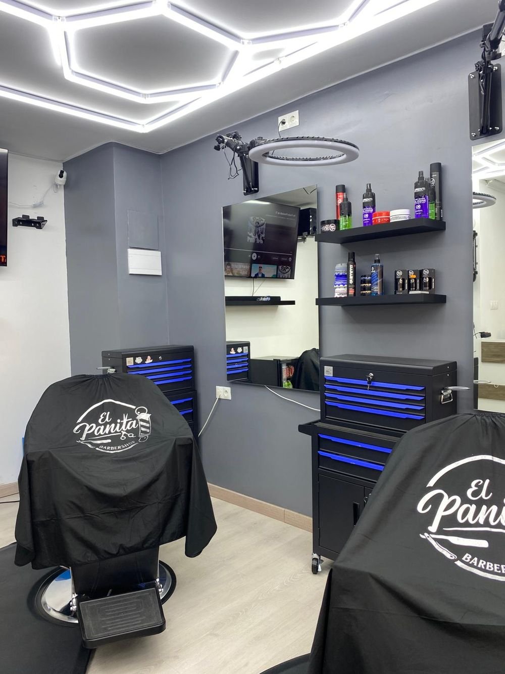 Puesto de barbero con espejo, carro de herramientas y producto profesional